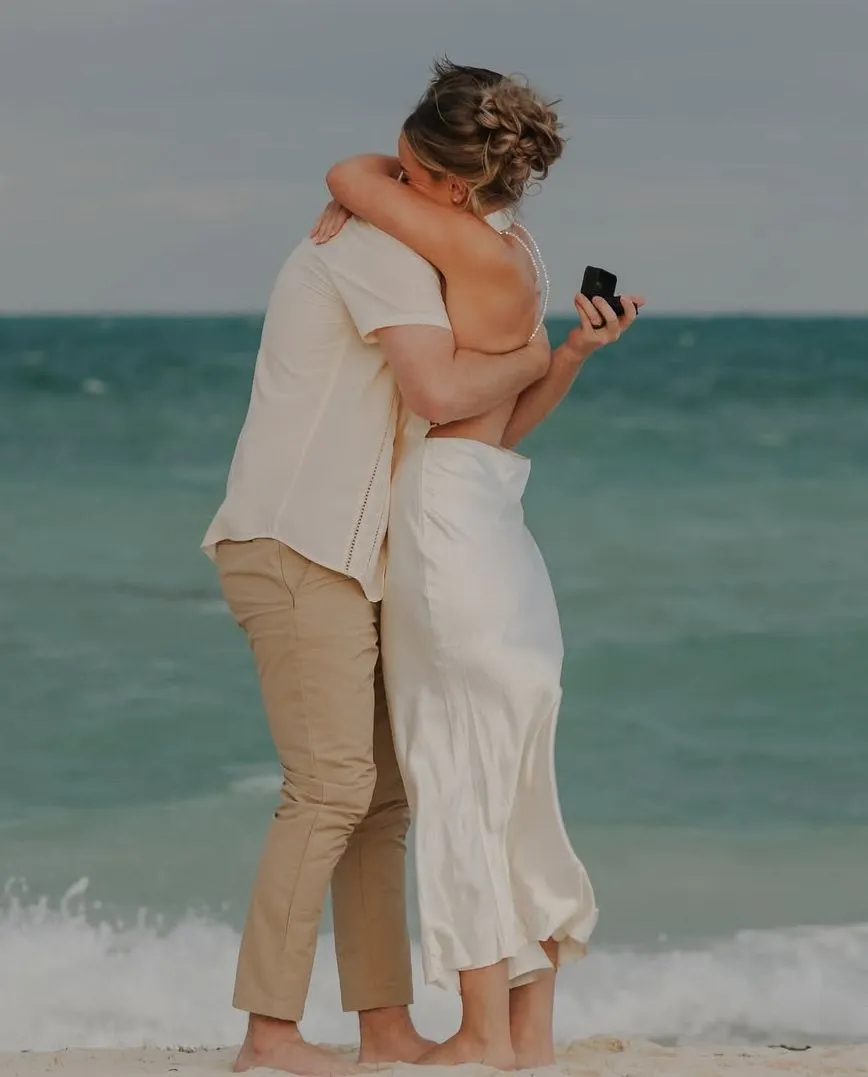 A couple embracing after their engagement on the beach at Secrets Playa Mujeres