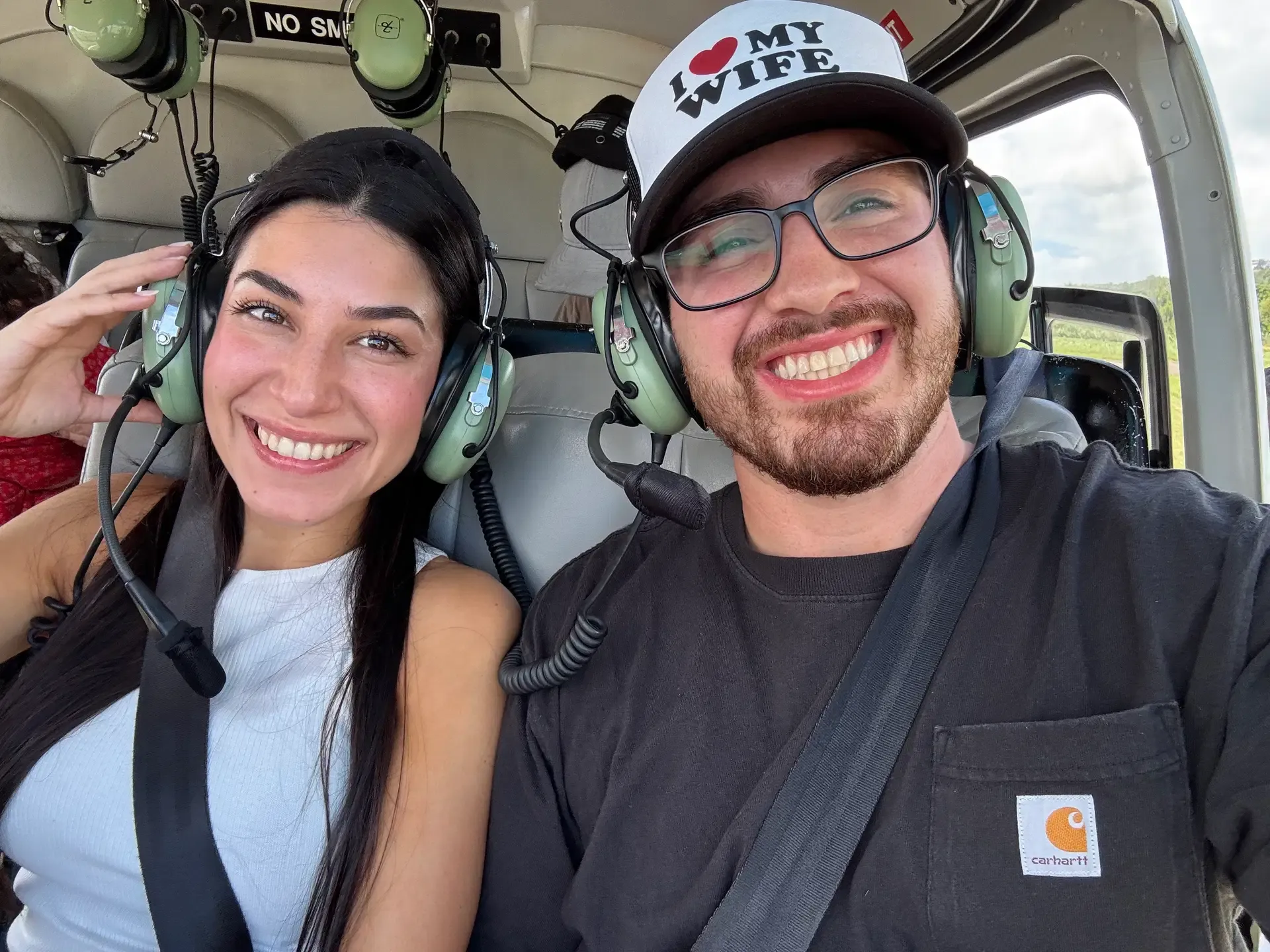 A honeymoon couple smiling together during a helicopter excursion in St. Lucia